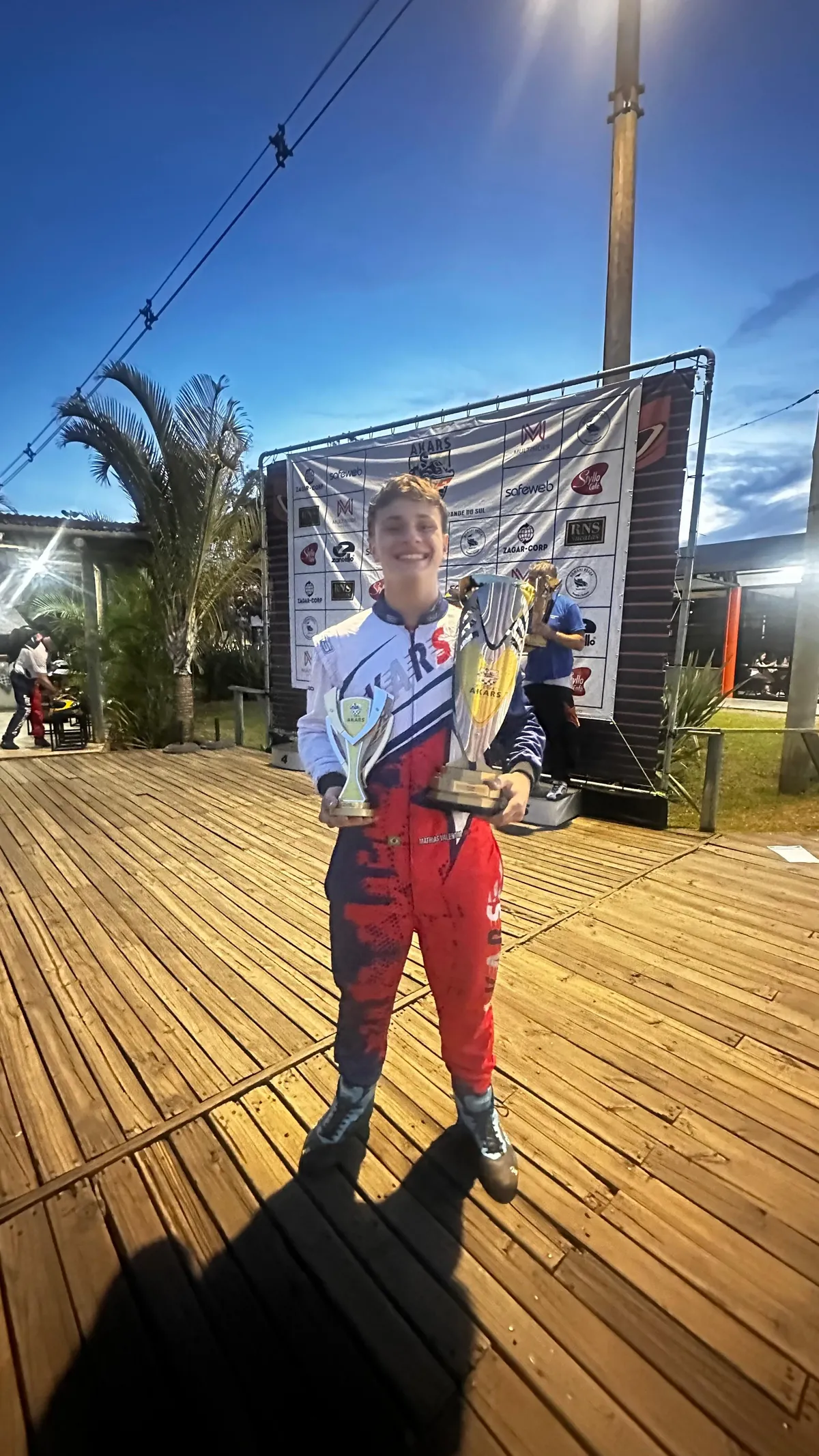 Piloto comemorando no pódio da 1ª Copa AKARS